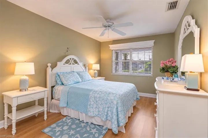 Wood-finish flooring, ceiling fan, and window with blinds