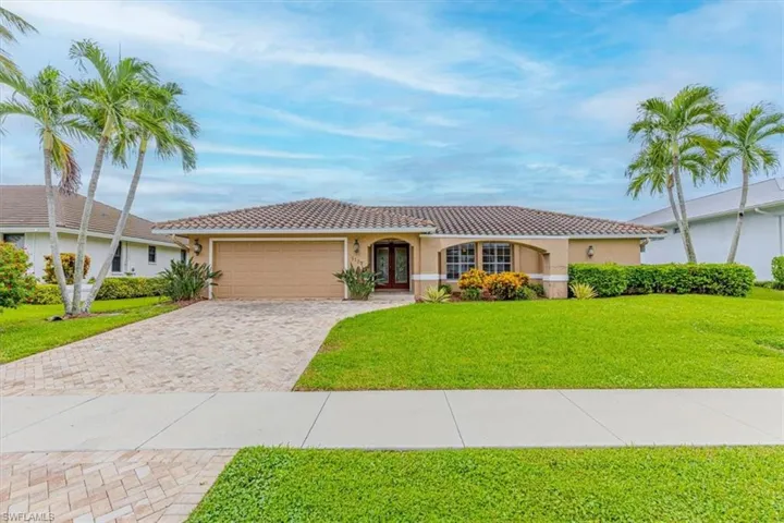 Single-story residence featuring a tile roof, stucco exterior, and an arched entry