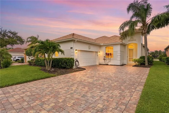 Stucco exterior with a tile roof and an arched entryway