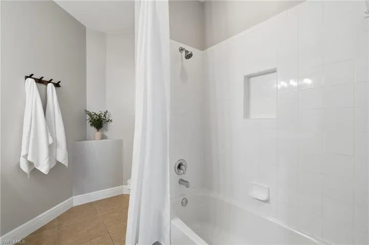 White subway tile bathtub surround with a built-in shower niche and chrome fixtures