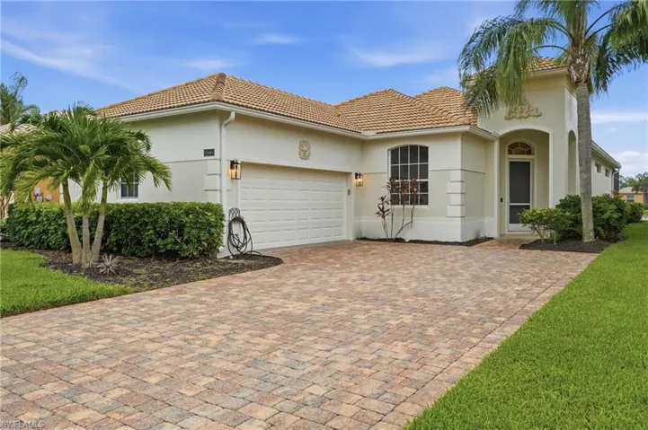 Stucco exterior with a tile roof and decorative archway over the entry