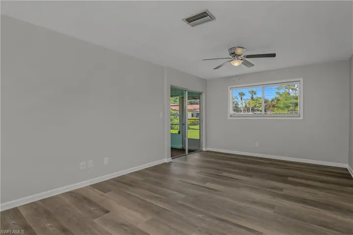 Living Room leading out to the Den/Flex Room with landscaped views