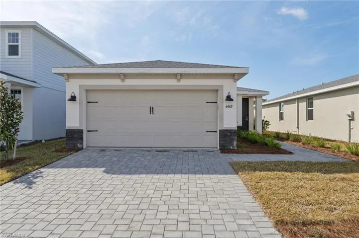 View of front of house with a garage and a front lawn