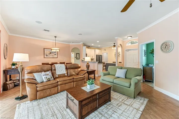 Living room featuring ceiling fan, light hardwood / wood-style floors, and ornamental molding