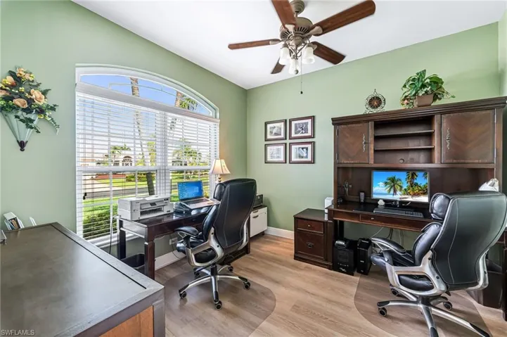 Office with light wood-type flooring and ceiling fan