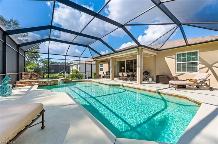 View of swimming pool with an in ground hot tub, a patio, ceiling fan, and a lanai