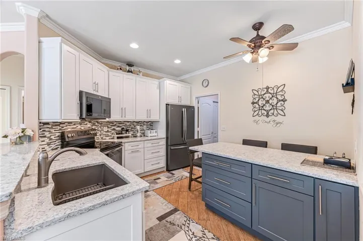 Kitchen with white cabinets, light hardwood / wood-style floors, sink, and appliances with stainless steel finishes