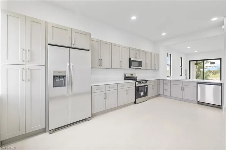 Kitchen featuring stainless steel appliances, light countertops, gray cabinetry, recessed lighting, and light flooring