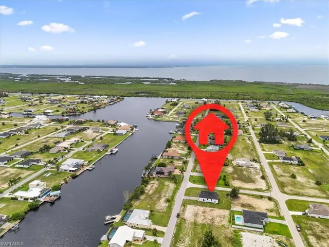 Aerial view of property and surrounding area with a large body of water and nearby suburban area
