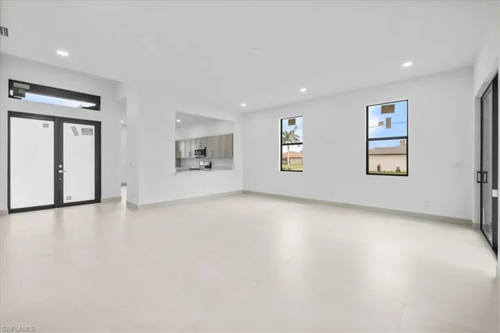 Unfurnished living room featuring recessed lighting and baseboards