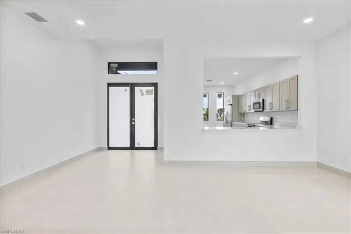 Unfurnished living room with recessed lighting and french doors
