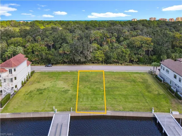 Aerial view of property and surrounding area with a nearby body of water and property boundaries highlighted