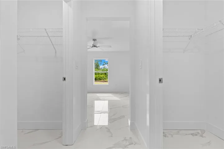Bathroom with a walk in closet and a ceiling fan