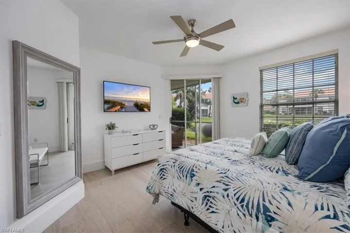 Bedroom with light wood finished floors, access to outside, and ceiling fan