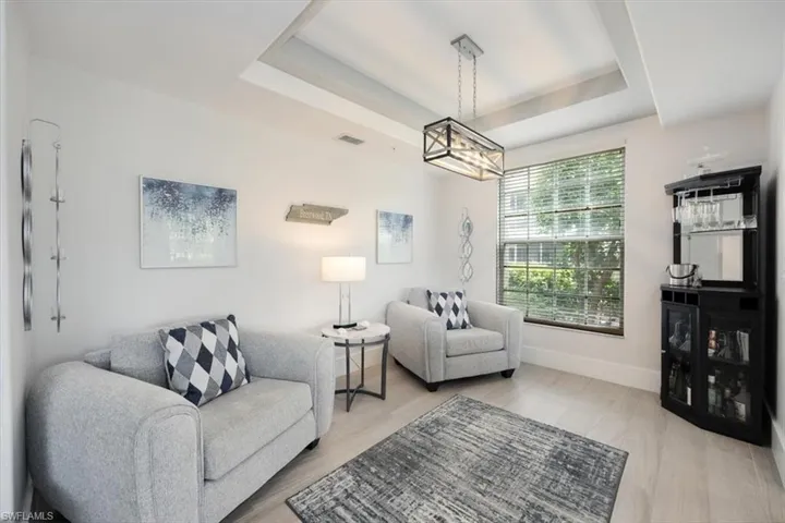 Living area featuring a tray ceiling and wood finished floors