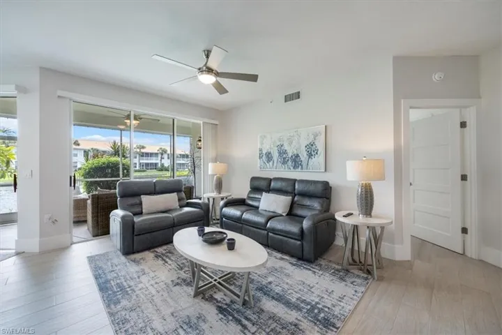 Living area with light wood finished floors and ceiling fan