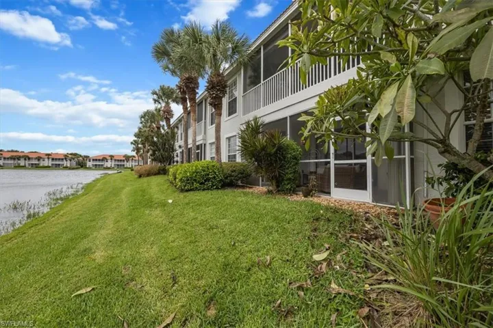 View of property's community with a water view, a sunroom, a yard, and a balcony