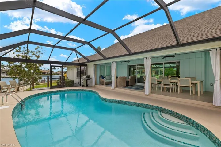 Outdoor pool with a sunroom, a ceiling fan, outdoor dining space, a lanai, and outdoor lounge area