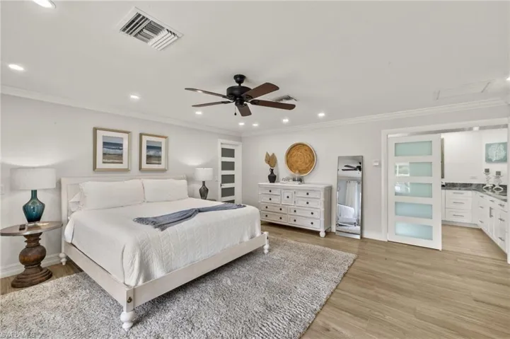 Bedroom featuring ornamental molding, recessed lighting, light wood-style flooring, and ceiling fan