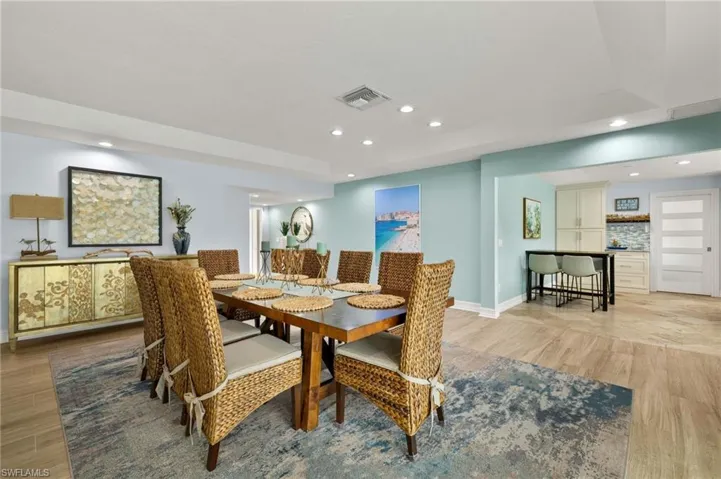 Dining area with light wood-style floors and recessed lighting