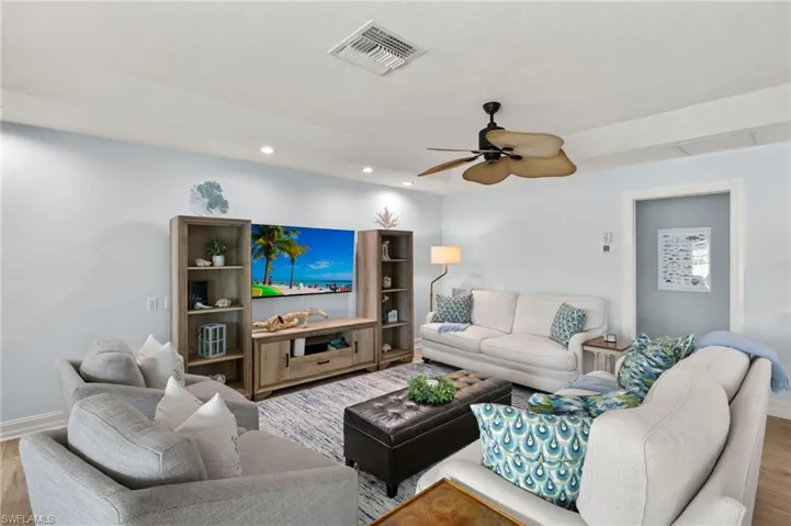 Living area with wood finished floors, a ceiling fan, and recessed lighting