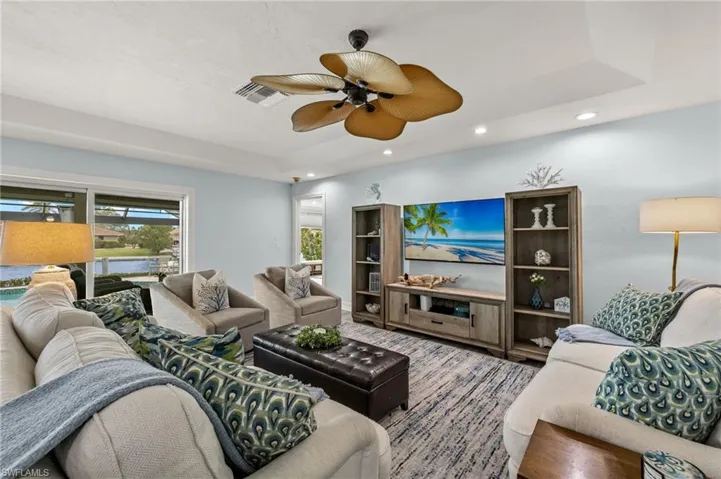 Living area featuring recessed lighting, a raised ceiling, and ceiling fan
