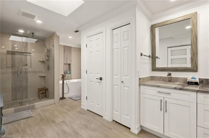 Full bath with vanity, a freestanding bath, a closet, a stall shower, and recessed lighting