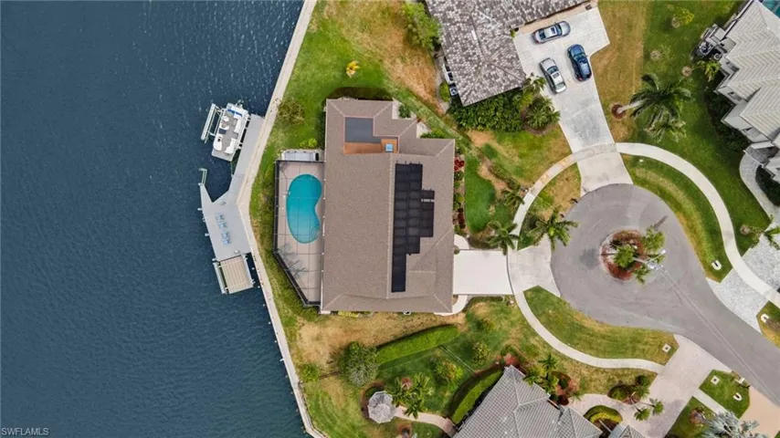 Aerial view of property and surrounding area with a pool and a large body of water