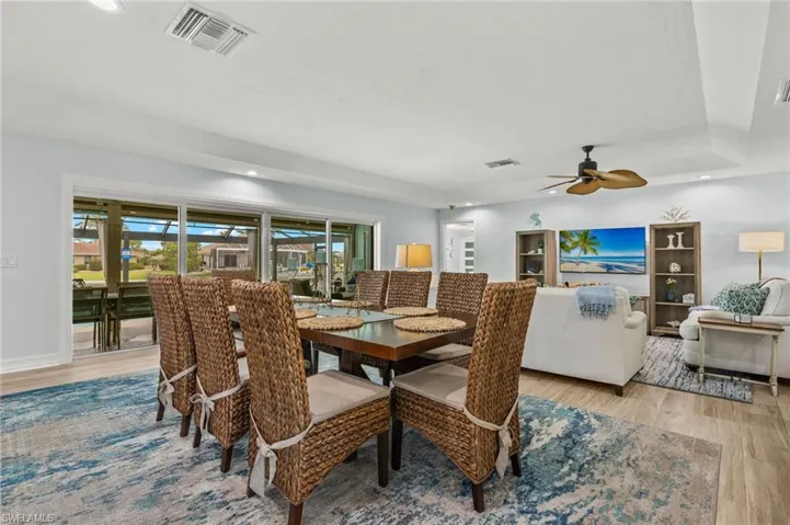 Dining area with recessed lighting, light wood-style floors, a ceiling fan, and a tray ceiling