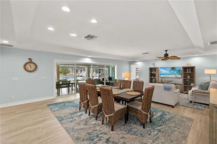 Dining space with recessed lighting, a raised ceiling, light wood-style floors, and ceiling fan
