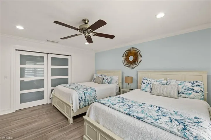 Bedroom with ornamental molding, recessed lighting, a ceiling fan, light wood-style floors, and a closet
