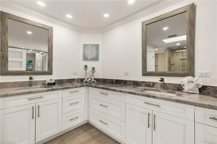 Full bath with double vanity, light wood-style floors, crown molding, and recessed lighting