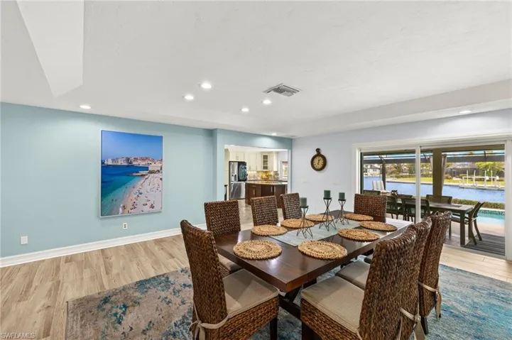 Dining room featuring light wood-style flooring, recessed lighting, and a water view