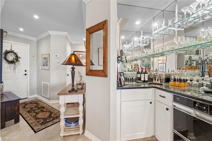 Entry area with light-toned flooring and crown molding