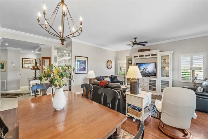 Dining area featuring a warm wood-finish table and an elegant multi-arm chandelier