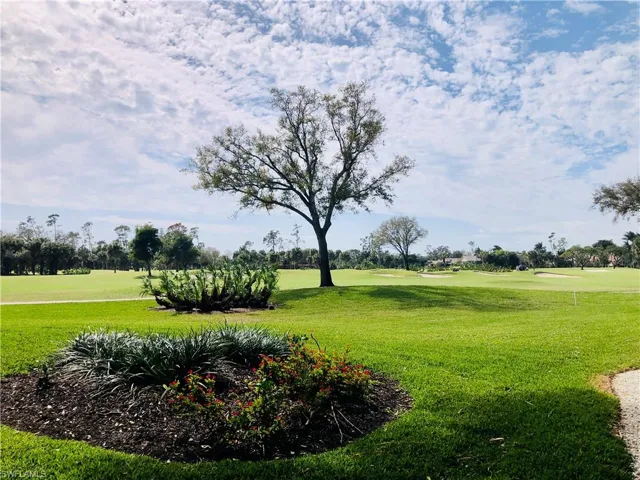 Expansive green space featuring manicured lawns and mature trees