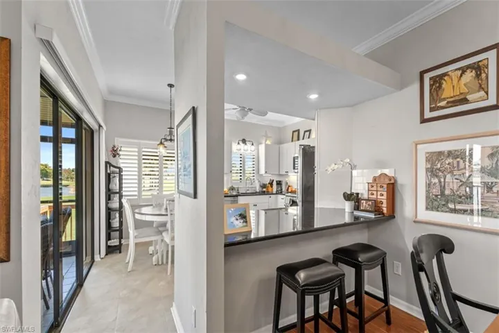 Kitchen pass-through with a breakfast bar featuring a dark countertop