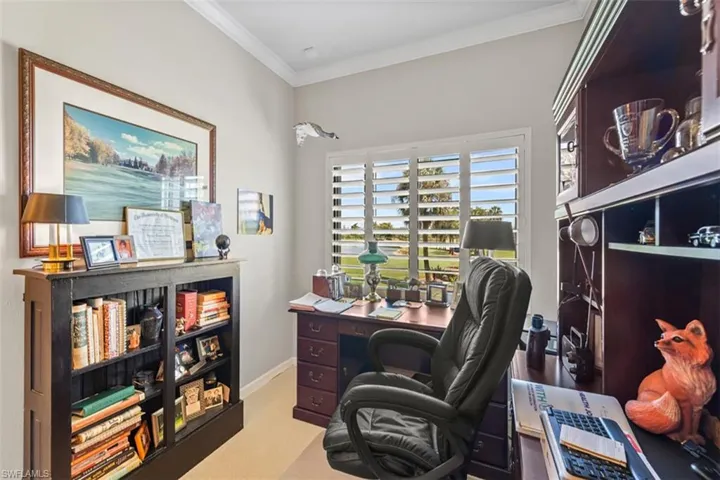 Dedicated workspace featuring a window with plantation shutters, crown molding, and light-toned wall paint