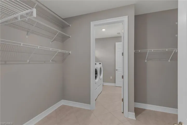 Walk in closet featuring washer and clothes dryer and tile patterned floors