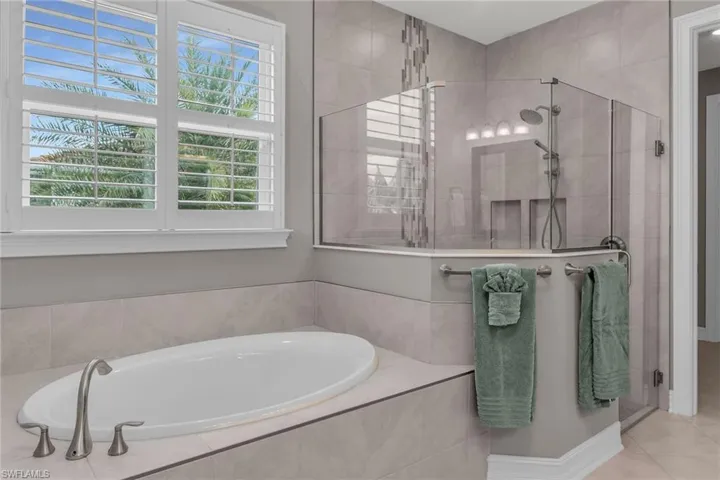 Bathroom with a stall shower, tile patterned flooring, and a bath