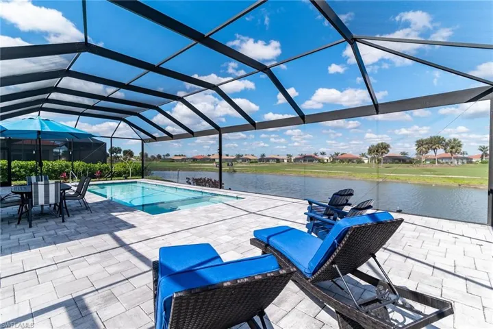 Pool with a lanai, a water view, and a patio