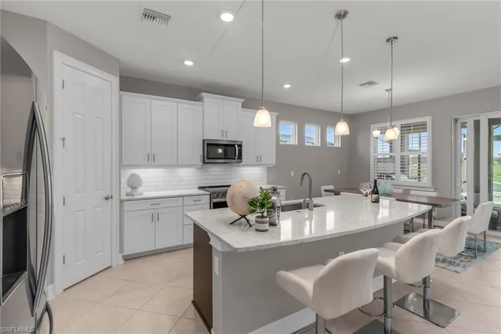 Kitchen with tasteful backsplash, visible vents, stainless steel appliances, a kitchen bar, and a sink