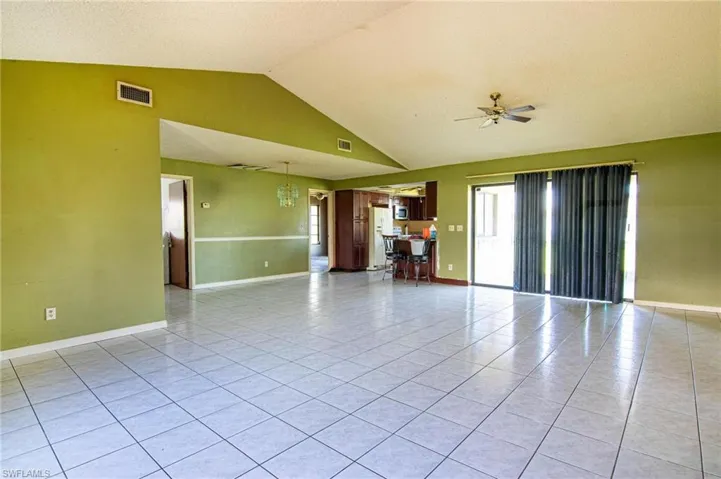 Unfurnished room featuring tile patterned floors, vaulted ceiling, and ceiling fan