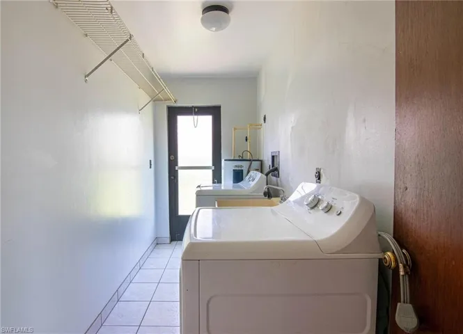 Washroom featuring washer and dryer and light tile patterned floors