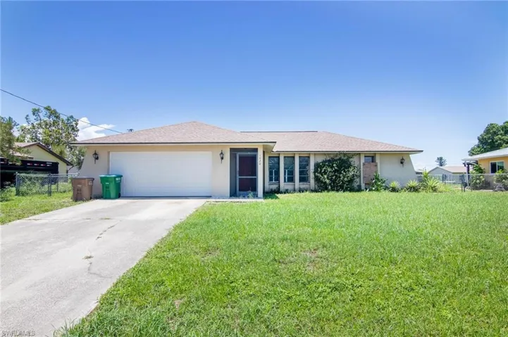 Ranch-style house with a garage and a front yard