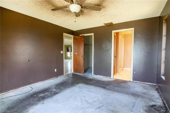 Unfurnished bedroom featuring a textured ceiling, ceiling fan, concrete floors, and a closet