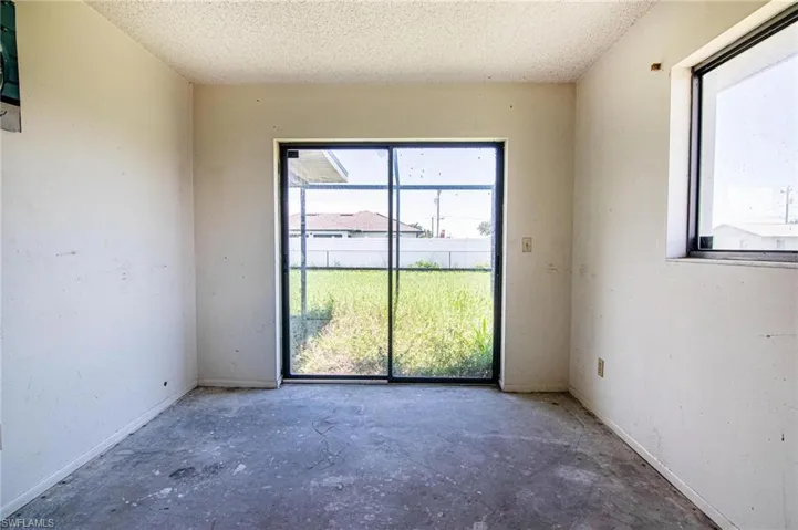 Spare room featuring plenty of natural light, concrete floors, and a textured ceiling