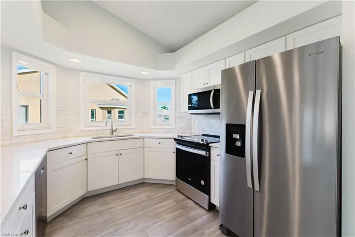 Kitchen featuring appliances with stainless steel finishes, lofted ceiling