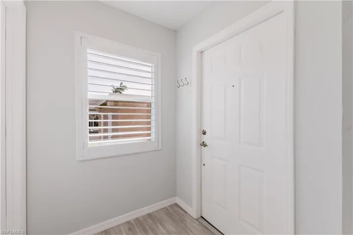 Entryway with baseboards and wood finished floors