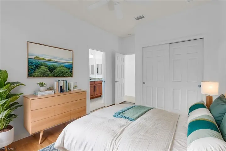Bedroom featuring ensuite bath, ceiling fan, a closet, and light hardwood / wood-style floors